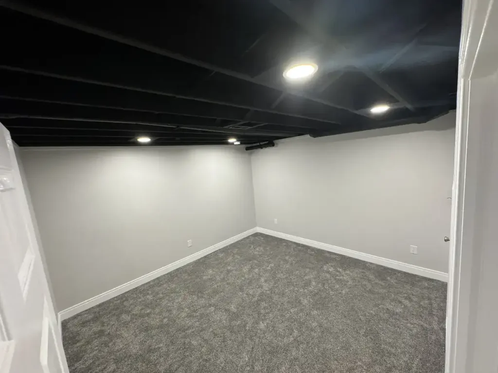 Full basement makeover featuring a spacious living area, an office, a bathroom, cozy carpet and trim for that at-home feel.