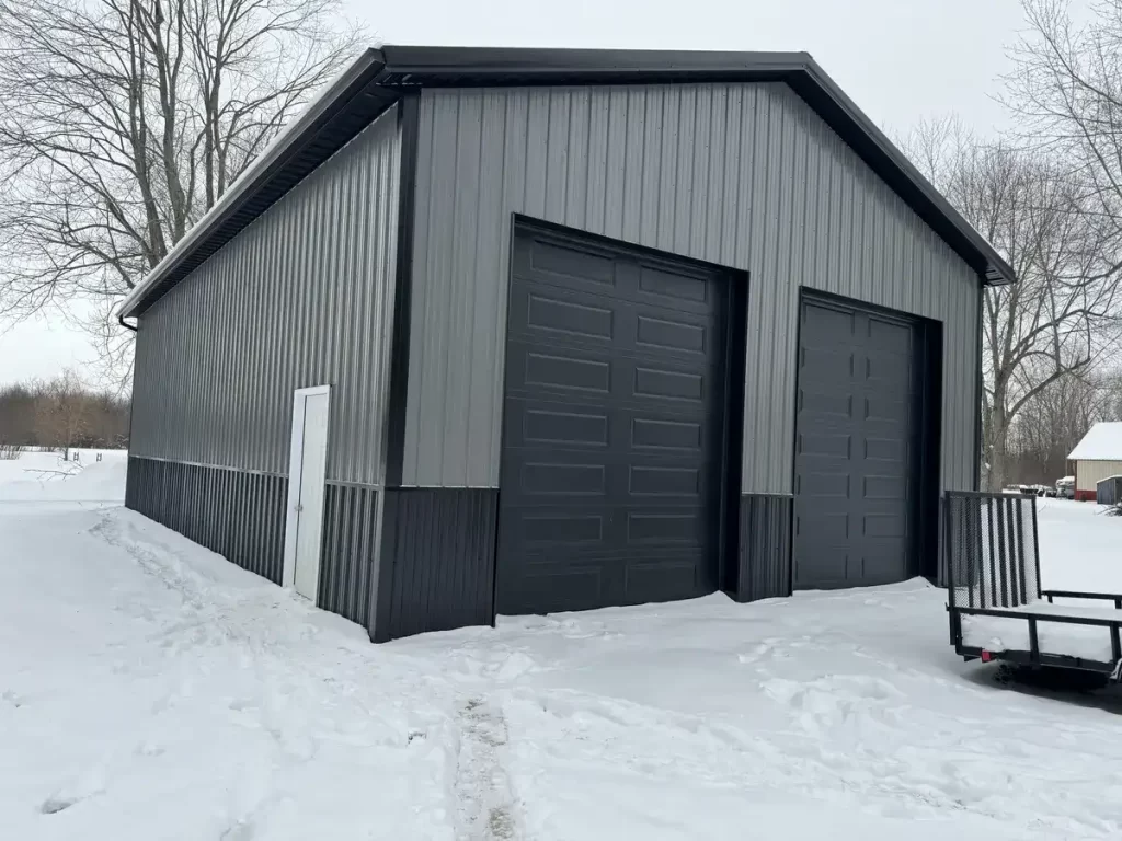 A Stately Pole Barn in East Amherst, NY, showcasing its sharp black and grey color scheme against a snowy backdrop.