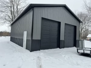 A Stately Pole Barn in East Amherst, NY, showcasing its sharp black and grey color scheme against a snowy backdrop.