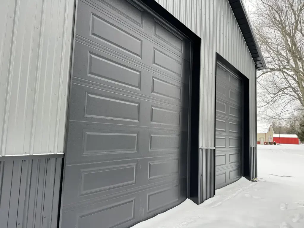 Close-up of the textured siding and garage doors of a Stately Pole Barn in East Amherst, NY, displaying quality craftsmanship.