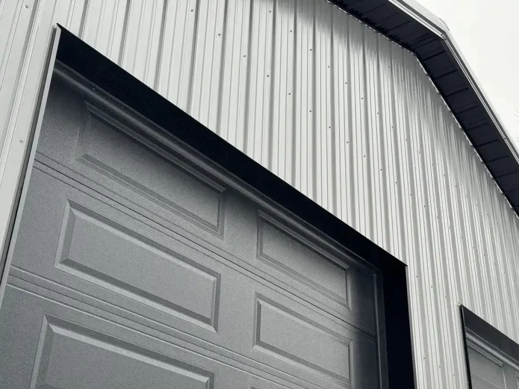 Close-up of the textured siding and garage doors of a Stately Pole Barn in East Amherst, NY, displaying quality craftsmanship.