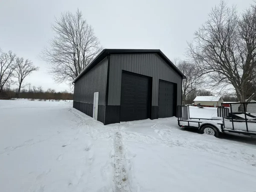 A Stately Pole Barn in East Amherst, NY, showcasing its sharp black and grey color scheme against a snowy backdrop.