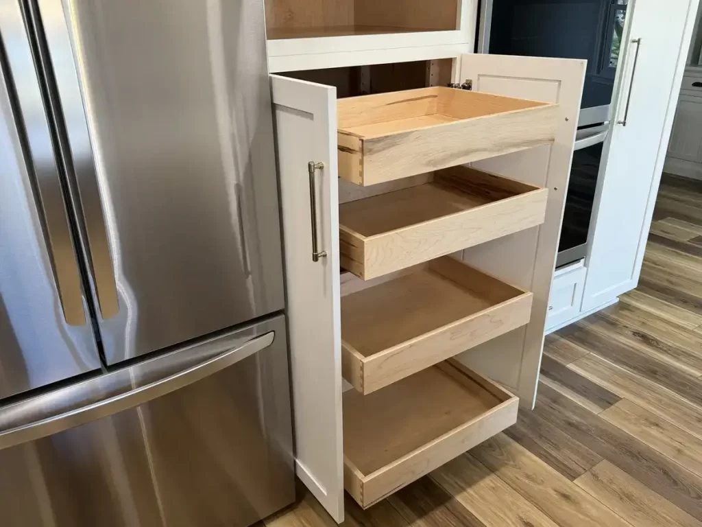 Custom kitchen storage solution with pull-out drawers by Reusch Woodworking, enhancing functionality in a remodeled Clarence, NY kitchen by Stately Kitchen & Bath.