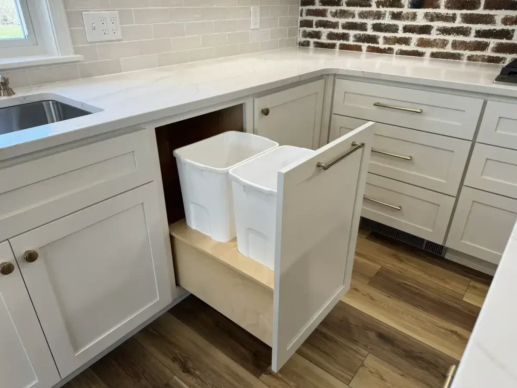 Custom-designed waste management drawer with dual bins for trash and recycling, part of a kitchen remodel in Clarence, NY by Stately Kitchen & Bath.