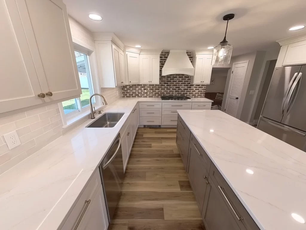 Spacious and modern kitchen remodel in Clarence, NY featuring white shaker cabinets, quartz countertops, and stainless steel appliances completed by Stately Kitchen & Bath.