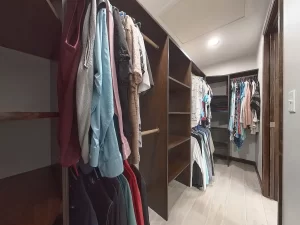 Walk-in closet with custom shelving and clothing racks in a bathroom remodel by Stately Kitchen and Bath in Gettzville, NY.