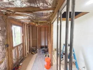 Demolished bathroom before remodel by Stately Kitchen and Bath in Gettzville, NY, showing exposed insulation, framing, and construction materials.
