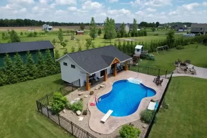 Side view of the pool house addition in Akron, NY, showcasing the overhang with custom millwork and the pool area, designed by Stately General Contracting.