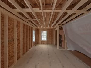 Primary bedroom construction progress by Stately General Contracting in Clarence, NY, featuring newly framed walls and ceiling.