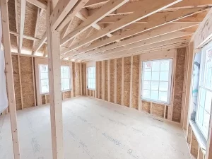 Stately General Contracting home addition in Clarence, NY, primary bedroom construction with framed walls and windows.