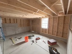 Expanded basement area under construction with framing, tools, and materials.