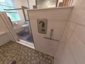 Stately General Contracting bathroom addition in Clarence, NY, showcasing the modern shower controls and sleek tile design.