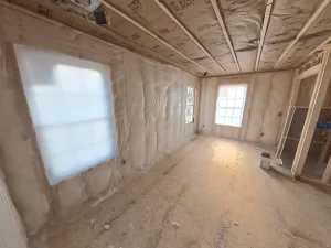 Spacious primary bedroom framing with installed windows and insulation in Clarence, NY home addition.