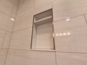Clarence, NY home addition by Stately General Contracting, showcasing a close-up of the built-in shower niche for convenient storage.