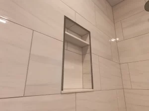 Stately General Contracting bathroom addition in Clarence, NY, highlighting the second built-in shower niche with sleek tile design.