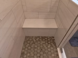 Interior view of the newly added bathroom by Stately General Contracting in Clarence, NY, featuring a built-in shower bench for comfort and convenience.