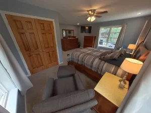 Primary bedroom suite addition in Clarence, NY by Stately General Contracting, featuring ample closet space and elegant furniture.