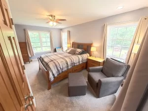 Stately General Contracting primary bedroom suite in Clarence, NY, highlighting the comfortable seating area and large windows.