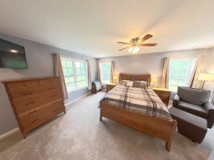 Stately General Contracting completed primary bedroom suite addition in Clarence, NY, featuring a cozy bed and stylish decor.