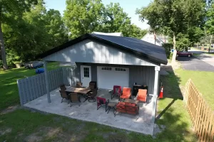 Rear view of a 24x36x10 pole barn in Clarence, NY, showcasing the extended outdoor pavilion area, constructed by Stately Pole Barns.