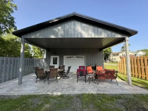 Rear view of a 24x36x10 pole barn in Clarence, NY, featuring durable construction by Stately Pole Barns and ample surrounding space.