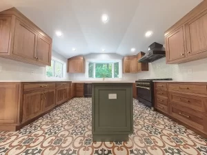 Remodeled Elma, NY, kitchen with a bright, open layout, patterned tile floor, and a sleek matte black stove with gold accents.