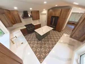 Elma, NY, kitchen post-remodel featuring a custom island with built-in storage, surrounded by wooden cabinetry and patterned tile flooring.