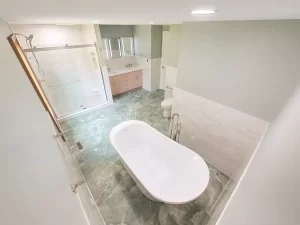 Bird’s-eye view of a contemporary bathroom remodel by Stately Kitchen and Bath, featuring a freestanding bathtub, glass-enclosed shower, and dual-sink vanity.