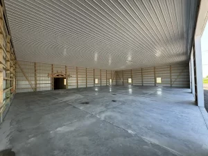 Interior view of the completed Bennington Highway Department pole barn, featuring a polished concrete floor, metal ceiling liner package, and open framework along the walls.