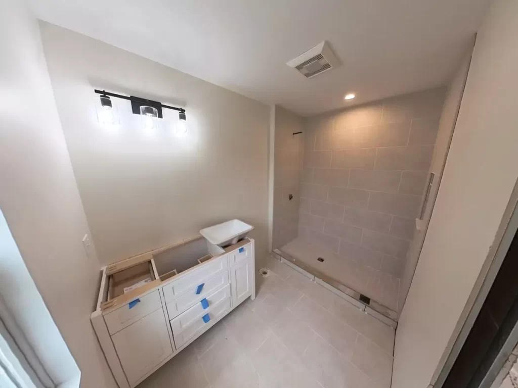 Bathroom in Amherst, NY home addition by Stately with new vanity and tiled shower, ready for final fixture installation.