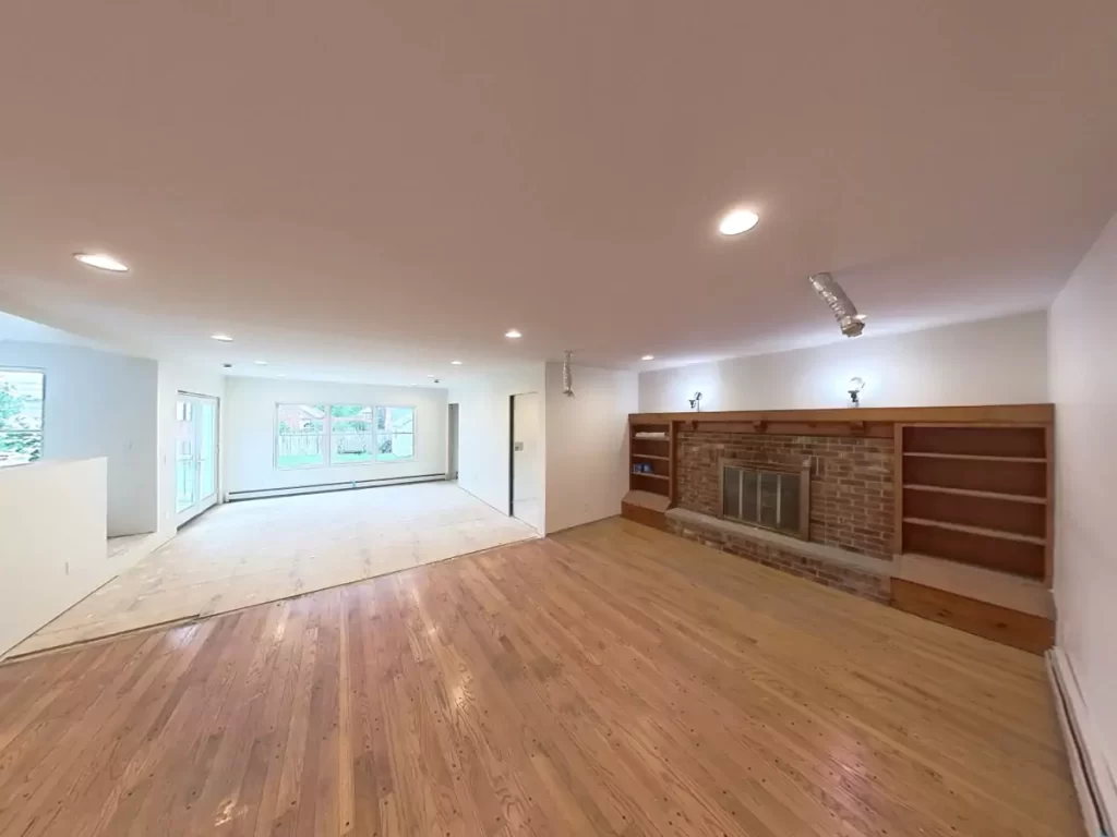 Living room expansion in Amherst, NY addition project by Stately, blending original and new flooring for a seamless finish.