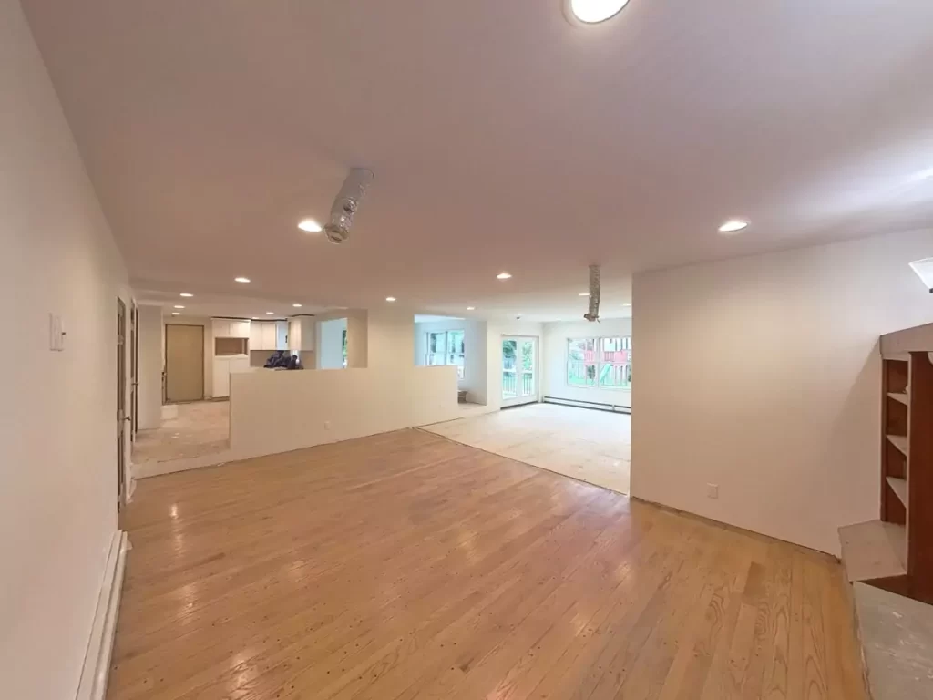 Open concept living area in Amherst, NY home addition by Stately, highlighting bright space and hardwood flooring.