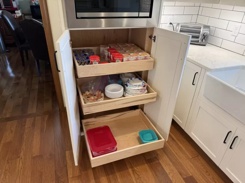 Pantry cabinet with pull-out shelves, showcasing organized storage space for easy access in a modern kitchen.