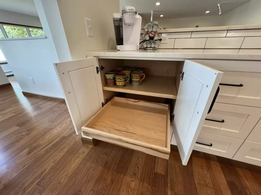 Open cabinet with wooden pull-out drawer, optimized for efficient storage in a contemporary kitchen design.