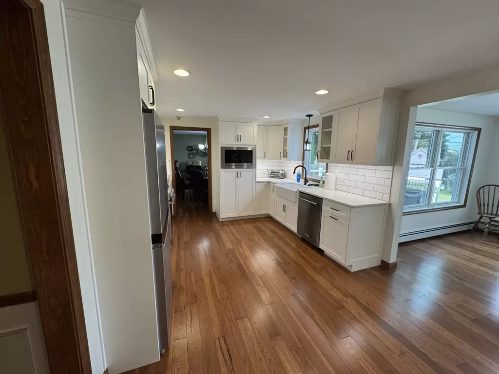 Modern kitchen with farmhouse sink, stainless steel appliances, and large windows bringing in natural light and warmth.