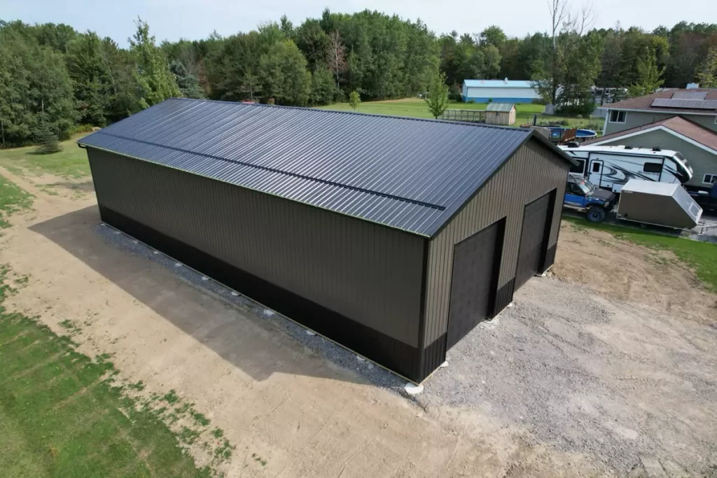 Aerial view of Stately’s 80x40x16 pole barn in Holland, NY, showcasing black roofing, charcoal siding, and the surrounding landscape.