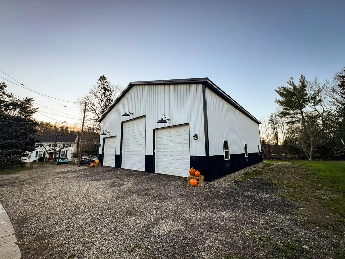 Landscape view of a Stately Pole Barns’ modern pole barn blending seamlessly into Holland, NY’s serene countryside.