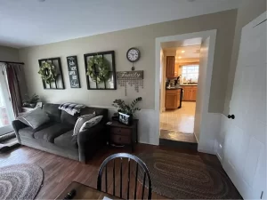 Living room with a small doorway leading into kitchen before renovation in Clarence, NY.
