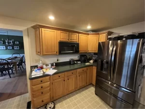 Kitchen before remodeling with dated wooden cabinets and basic countertops in Clarence, NY.