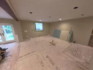 Spacious remodeled kitchen with recessed lighting, drywall installation in progress, and large patio doors.