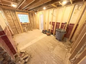 Kitchen demolition exposing brick walls and framing in Clarence, NY renovation project.