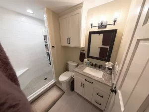 Bathroom with custom vanity, granite countertop, and tile flooring, designed for functionality and style by Stately Kitchen and Bath.