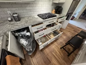 Modern kitchen drawers with organized utensils and pots, highlighting functional storage design.