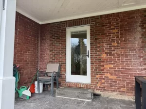 Newly installed man door by Stately Kitchen and Bath remodel, featuring expert masonry to seamlessly match the home’s original brick exterior.