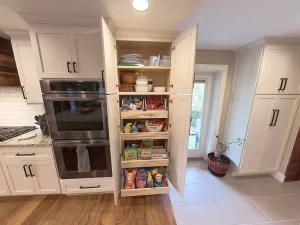 Pull-out pantry with organized snacks and kitchen essentials, showcasing Stately Kitchen and Bath’s storage solutions.
