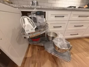 Corner cabinet with pull-out shelves, perfect for storing small kitchen appliances and cookware.