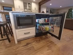 Island-mounted microwave drawer and mini-fridge for beverages and convenience items. Part of a Stately Kitchen and Bath remodel.
