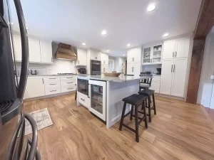 Bright and stylish kitchen with granite island, white cabinets, and wood flooring for a modern feel.