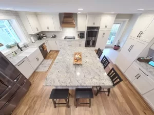 Granite kitchen island centerpiece with bar seating and integrated storage, part of a Stately Kitchen and Bath remodel in Clarence, NY.
