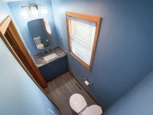 Stately bathroom remodel featuring a custom vanity, stone countertop, and upgraded lighting in Akron, NY.